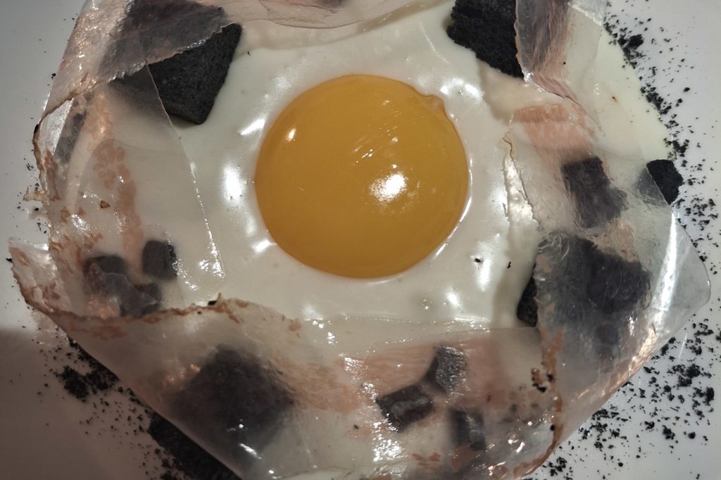 Uovo " carbonara" : spuma di pecorino, guanciale trasparente, cubetti di pane al carbone